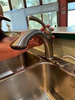 Davis Plumbing installing a brushed-nickel pull-down kitchen faucet in Whitney, TX