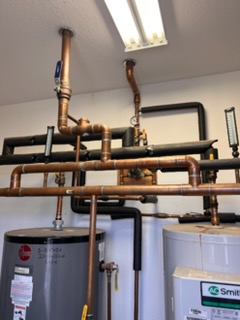 Copper water heater piping and recirculation lines in a utility room